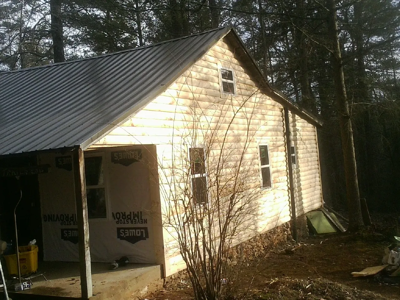 Log siding gable end under a dark metal roof edge in East Pittsburgh