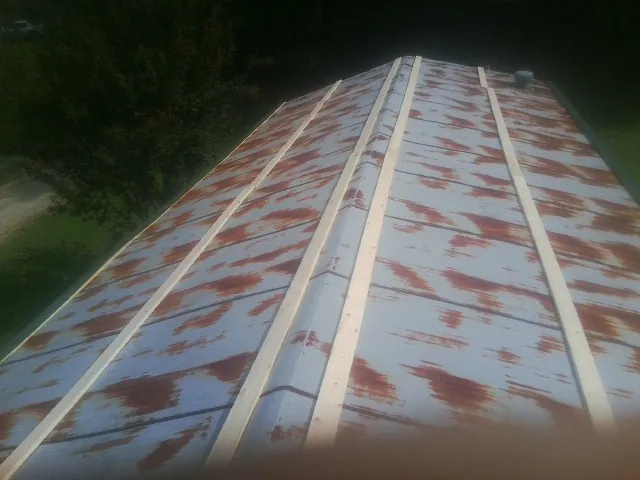 Rusted metal roof panels with new wood purlins before replacement — Storm Damage Roof Repair in East Pittsburgh by Roofing Brothers