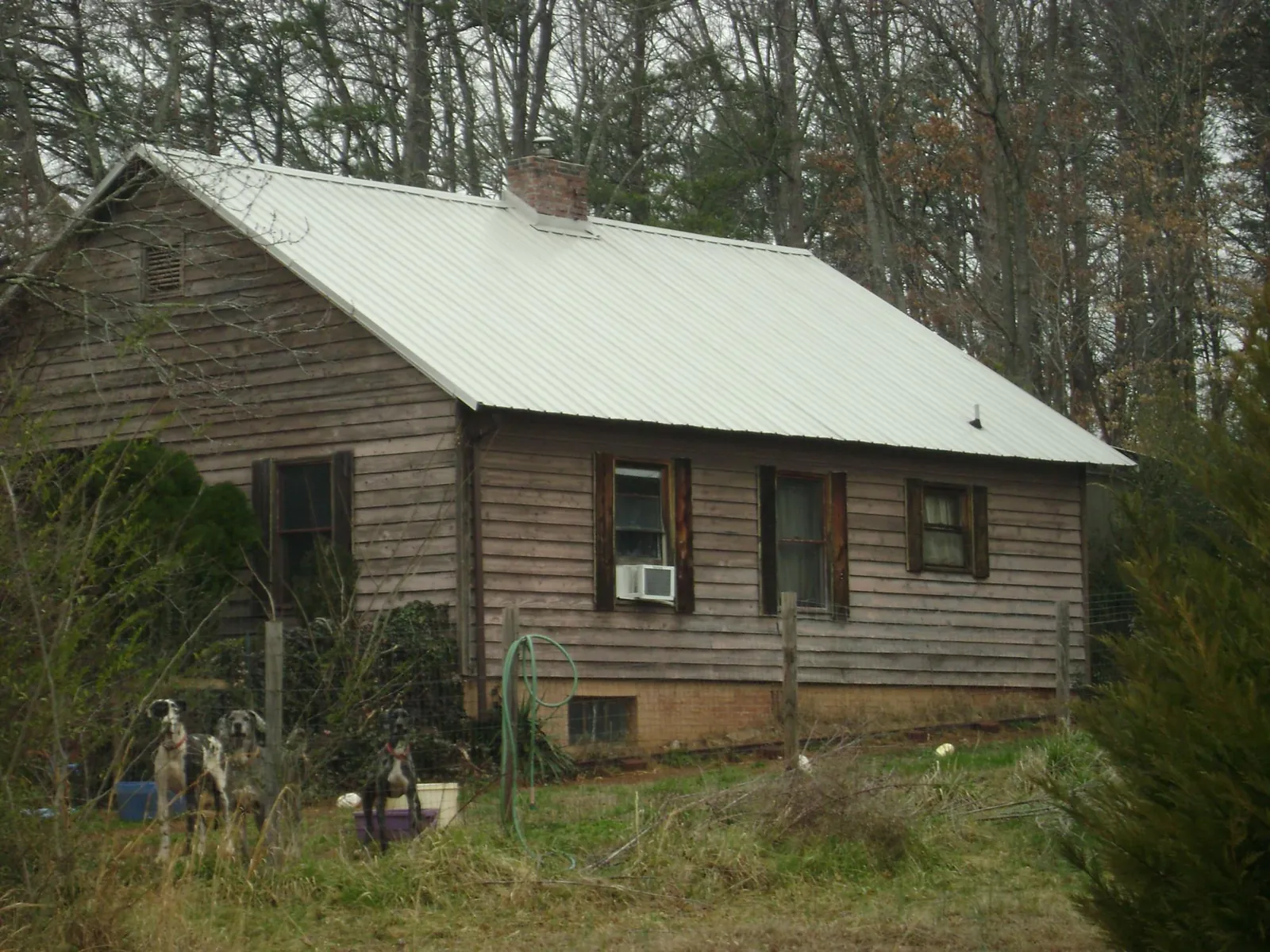 White metal roof on an old wood sided farmhouse, from a Asphalt Shingle Roof Repair job in East Pittsburgh